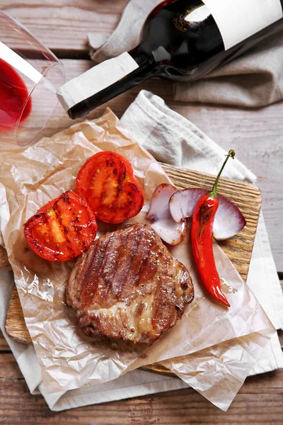 Roasted beef fillet and vegetables on cutting board, on wooden background — Stock Photo, Image