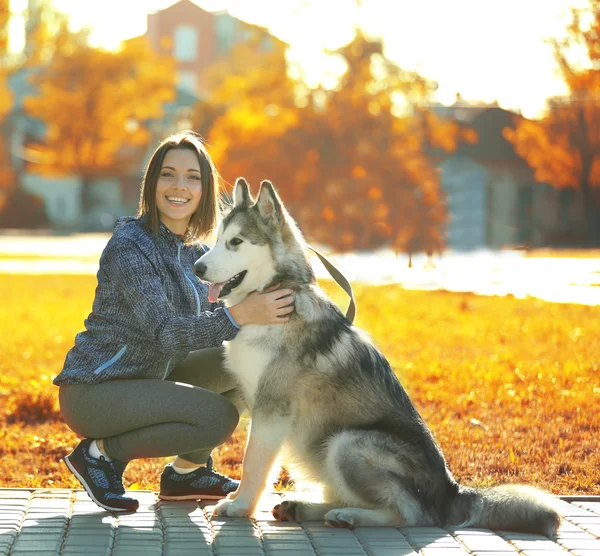 Vrouw wandelen met haar hond in park — Stockfoto