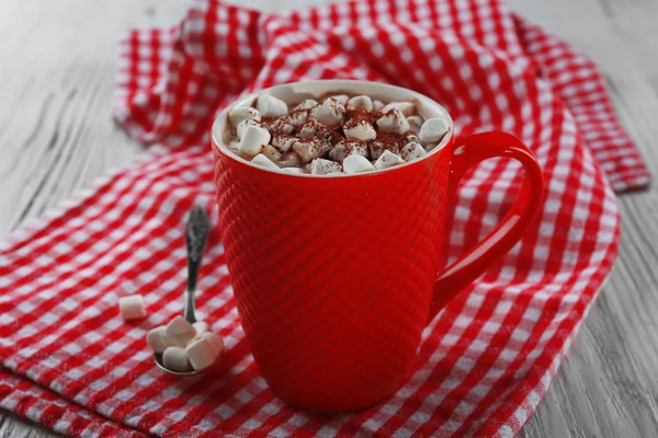 Een kopje van smakelijke cacao en marshmallow op geruite servet achtergrond — Stockfoto