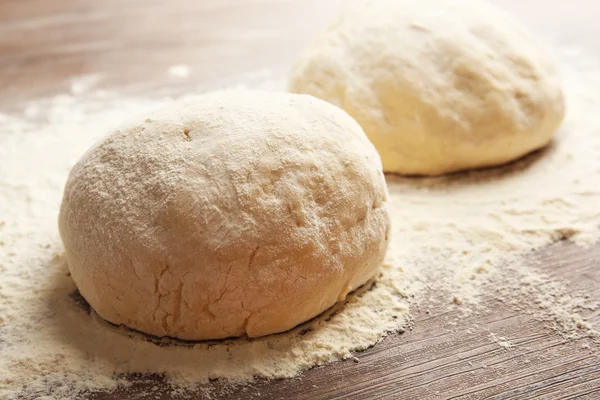 Bolas de masa para pizza sobre tabla de madera enharinada —  Fotos de Stock