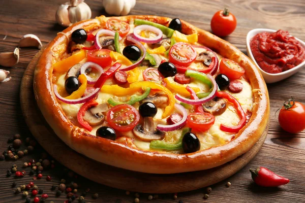 Pizza deliciosa com legumes, na mesa de madeira, close-up — Fotografia de Stock