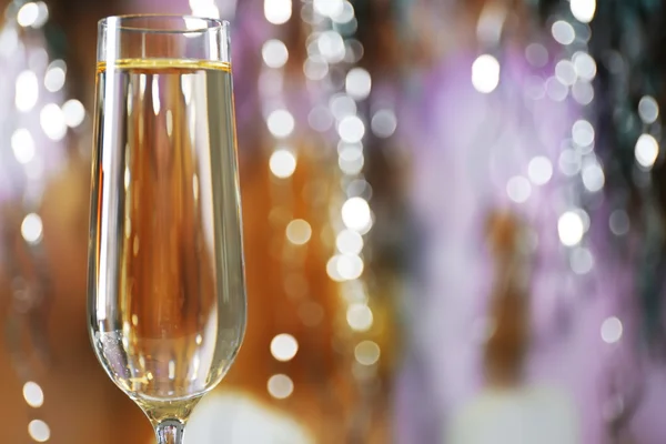 A glass of champagne on blurred lighted background — Stock Photo, Image