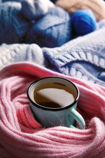 Mug of tea wrapped in scarf — Stock Photo, Image