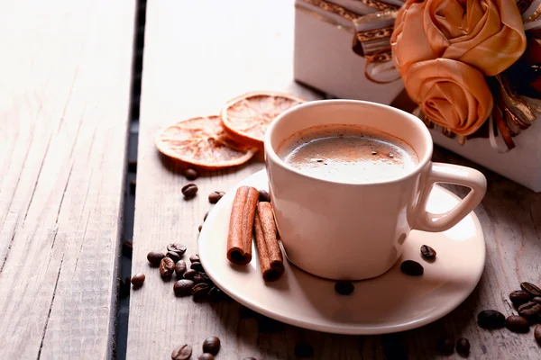 Bellissimo regalo, tazza con caffè e chicchi di caffè su sfondo di legno — Foto Stock