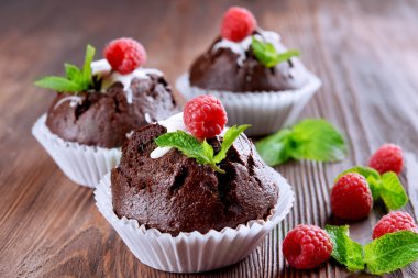 Çilek ve ahşap masa üzerinde taze nane ile lezzetli çikolata cupcakes yakın çekim