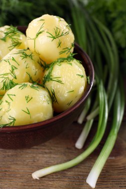 Masada bir kapta yeşillikleri ile haşlanmış patates yakın çekim