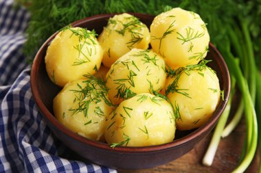 Masada bir kapta yeşillikleri ile haşlanmış patates yakın çekim