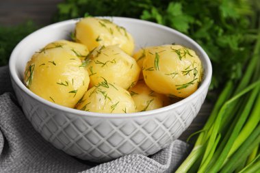 Masada bir kapta yeşillikleri ile haşlanmış patates yakın çekim