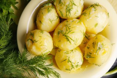 Masada bir kapta yeşillikleri ile haşlanmış patates yakın çekim