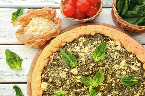 Pastel abierto con espinacas y cereza de tomate en la mesa de cerca —  Fotos de Stock