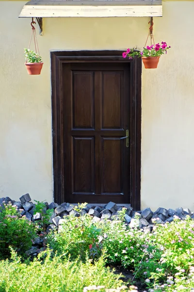 Drewniane drzwi z kwiatami w doniczkach — Zdjęcie stockowe