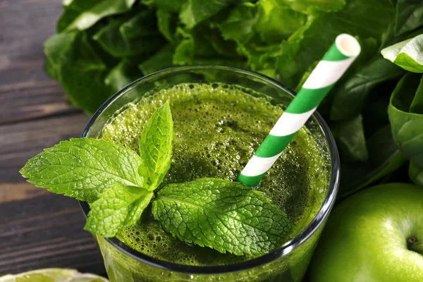 Succo sano verde con frutta ed erbe sul tavolo da vicino — Foto Stock