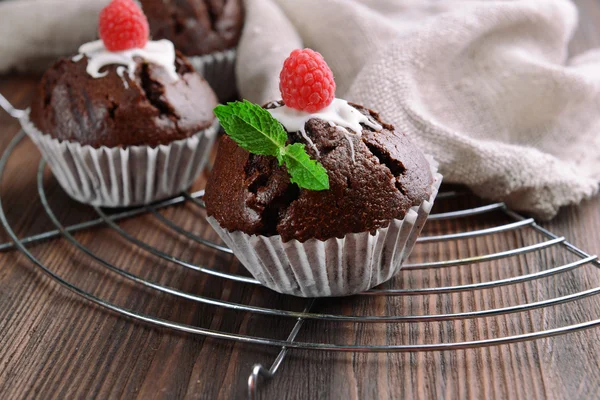 Leckere Schokoladen-Cupcakes mit Beeren und frischer Minze auf dem Tisch aus nächster Nähe — Stockfoto