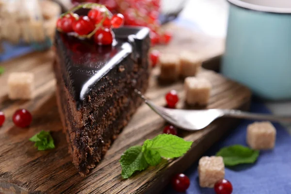 Bolo de chocolate saboroso com bagas na mesa de perto — Fotografia de Stock