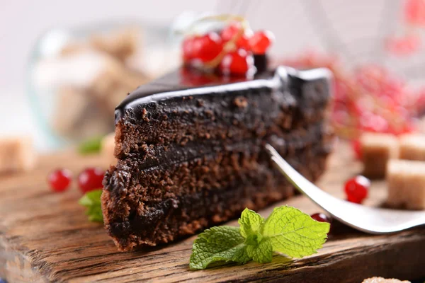 Bolo de chocolate saboroso com bagas na mesa de perto — Fotografia de Stock