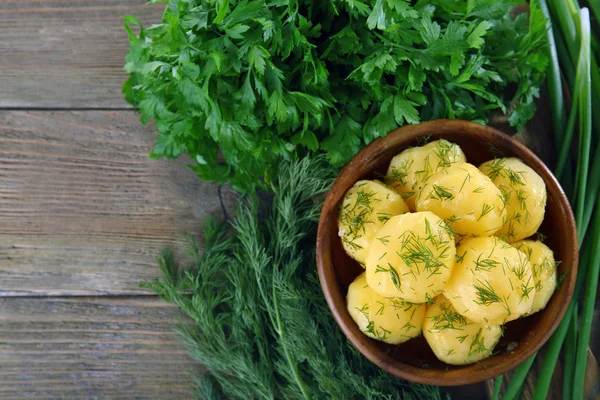 Las patatas cocidas con la verdura en la escudilla a la mesa se acercan —  Fotos de Stock