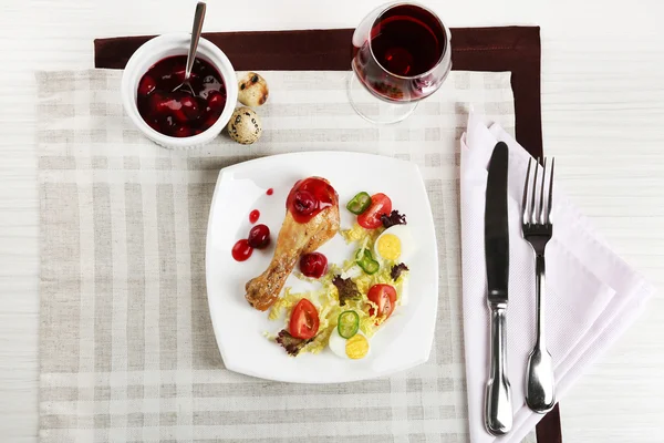 구운된 닭 다리와 냅킨, 상위 뷰 테이블에 와인의 유리를 가진 흰색 접시에 야채 샐러드 접시 — 스톡 사진