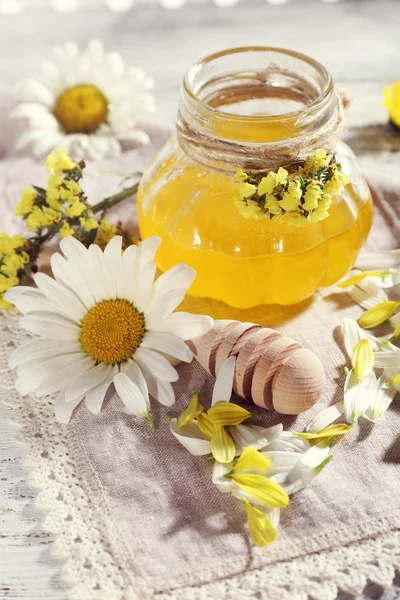 Honey and flowers on napkin closeup — Stock Photo, Image