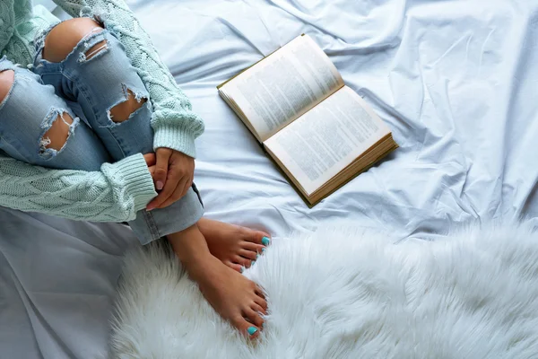 Mujer en jeans en la cama — Foto de Stock