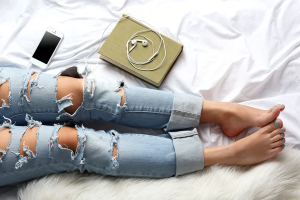 Mujer en jeans en la cama — Foto de Stock