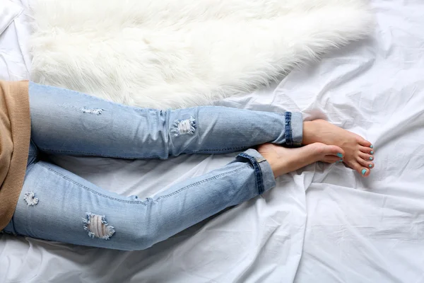 Woman in jeans on bed — Stock Photo, Image