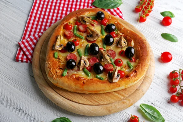 Szív alakú ízletes pizza és a fából készült háttér piros kockás pamut szalvéta — Stock Fotó
