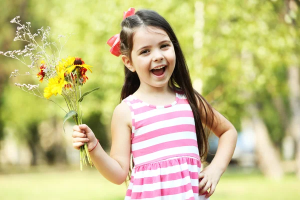 Šťastná holčička s květinami — Stock fotografie