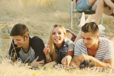 Mutlu gülümseyen arkadaşlar açık havada ormanda yalan