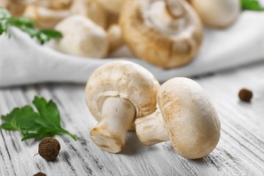 Champignon mantar ve baharat beyaz ahşap zemin üzerinde