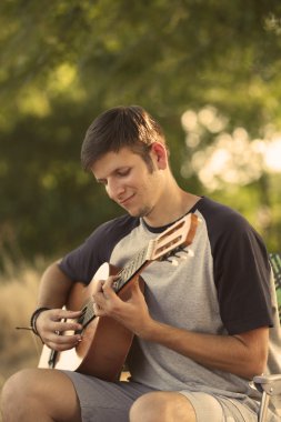 Çekici çocuk açık havada gitar çalmak