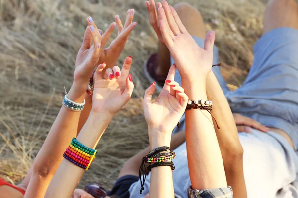 View on friends 'raised hands outdoors — стоковое фото