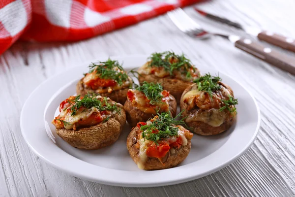 A plate with stuffed mushrooms on wooden background — Stock Photo, Image