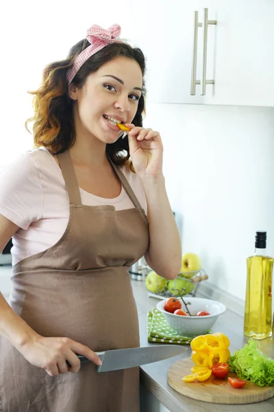 Mulher grávida corta verduras para salada — Fotografia de Stock