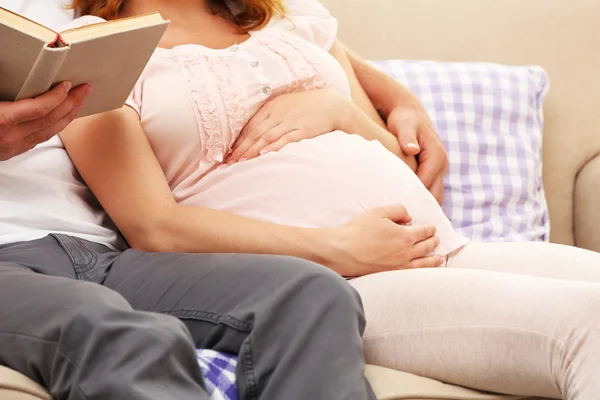 Man läser boken till sin gravida kvinna — Stockfoto