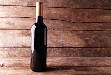 ahşap masa üstünde kırmızı şarap şişe