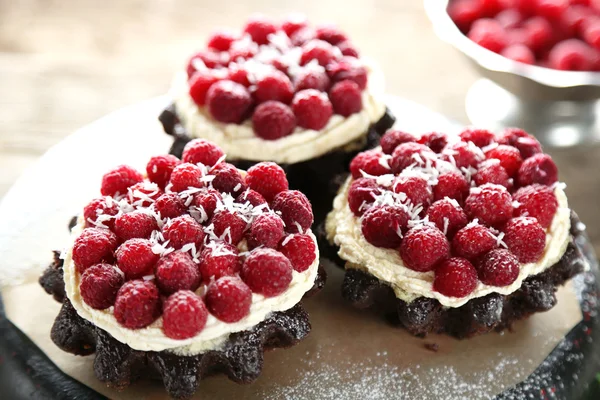 Gâteaux sucrés aux framboises sur fond de table en bois — Photo