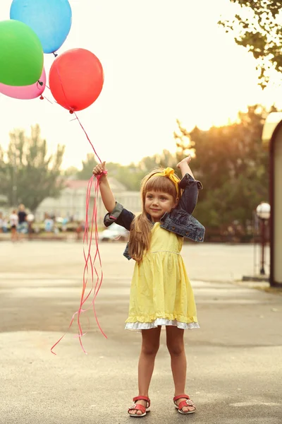 Liten flicka med ballonger — Stockfoto