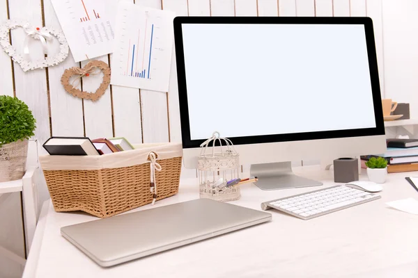 Computador moderno na mesa decorada contra a parede de madeira — Fotografia de Stock