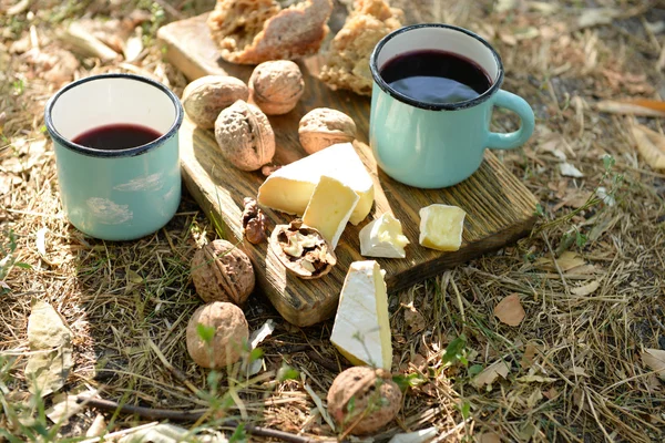 Tassen mit Rotwein, leckerem Käse und Nüssen — Stockfoto