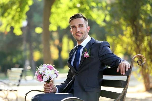 Brudgom som holder bryllupsbukett utendørs – stockfoto