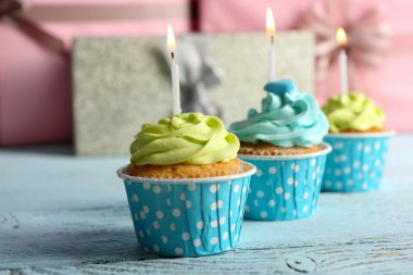 Ahşap arka plan karşı Menekşe masada mumlarla lezzetli kek