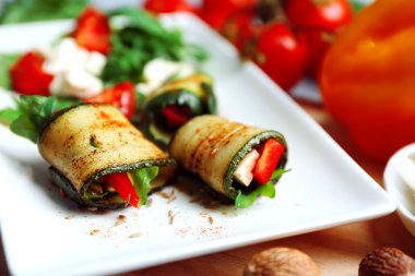 Kabak rulo peynir, biber ve roka ile tabağında, yakın çekim, tablo arka plan üzerinde