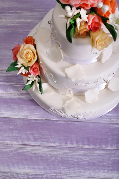 White wedding cake decorated with flowers on grey  wooden background — Stock Photo, Image