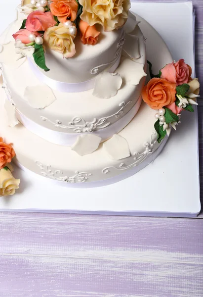 白色婚礼蛋糕装饰着花朵在木桌前，关闭 — 图库照片