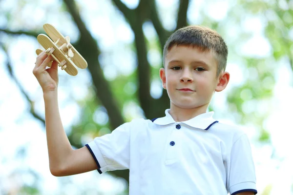 Little boy plays with wooden plane — Stock Photo, Image