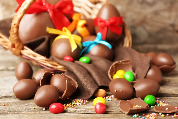 Huevos de Pascua de chocolate en cesta sobre fondo de madera —  Fotos de Stock