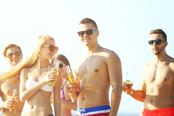 Amigos felices bebiendo cerveza en la playa — Foto de Stock