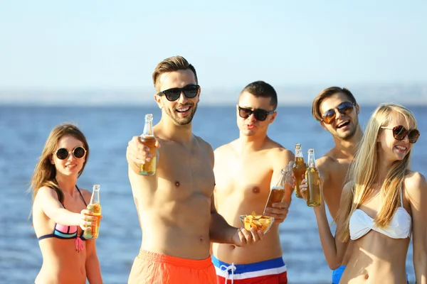 Happy friends drinking beer at beach — Stock Photo, Image