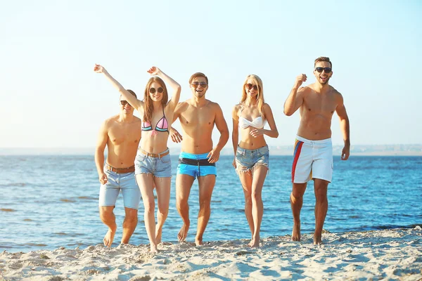 Amigos felices corriendo en la playa —  Fotos de Stock