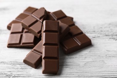 Renk ahşap arka plan üzerinde siyah çikolata parçaları